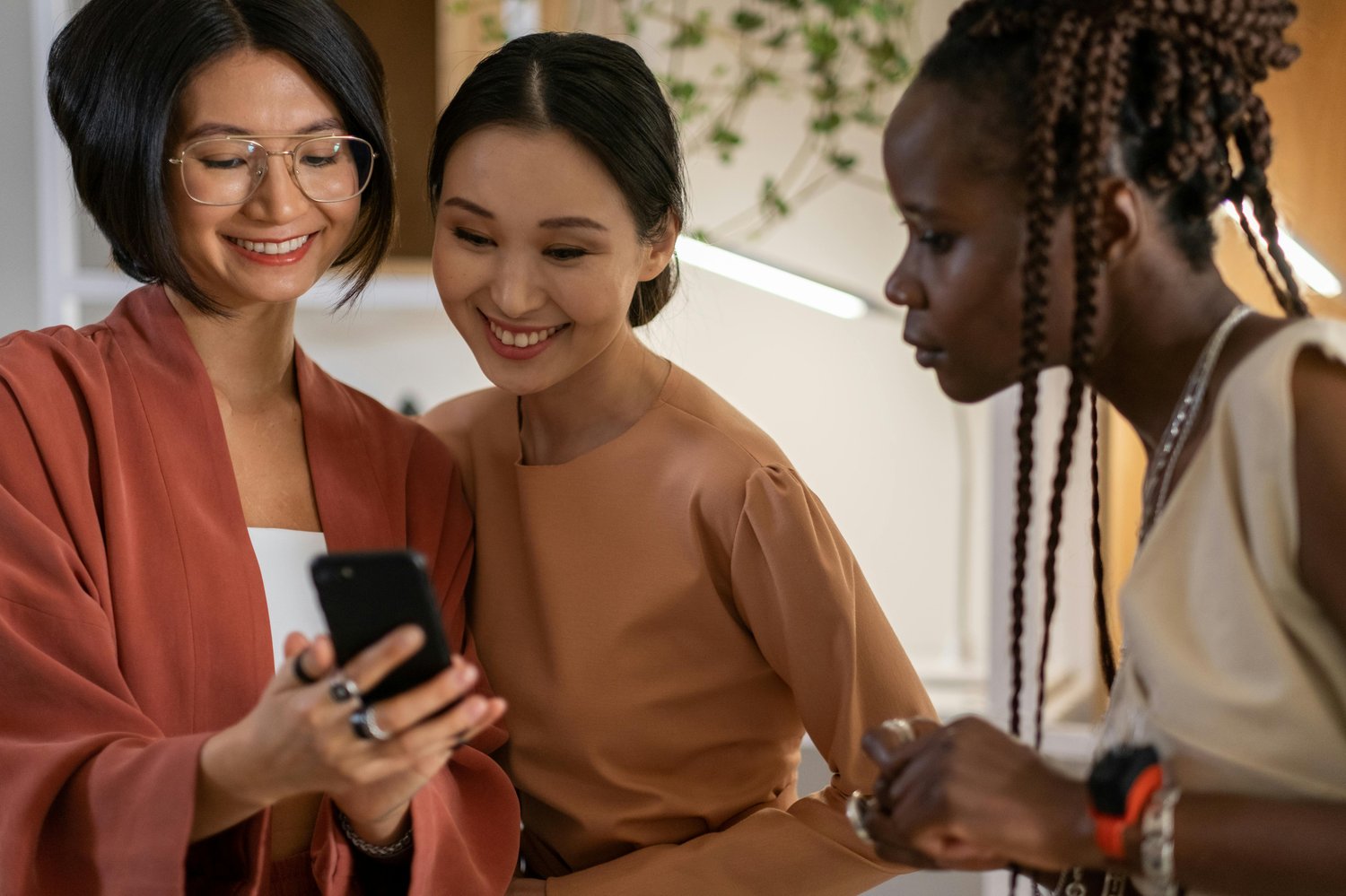 Three women looking at a smartphone app.